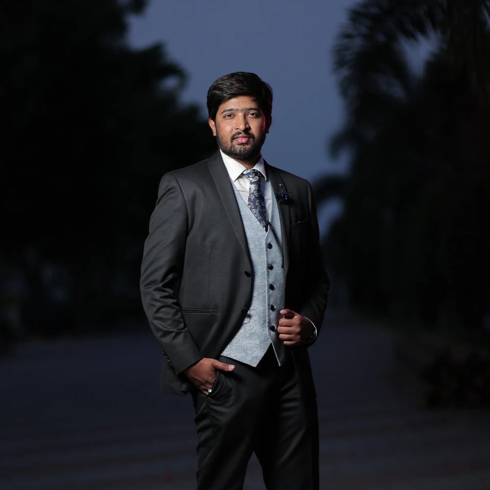Man in a formal suit outdoors at dusk