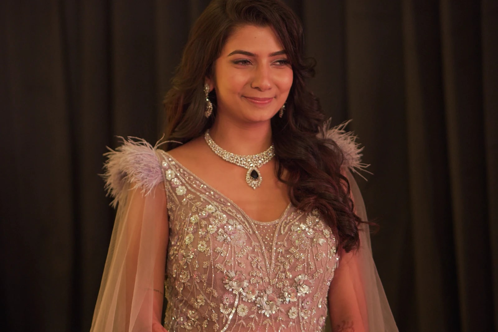 Woman smiling in a sparkling gown