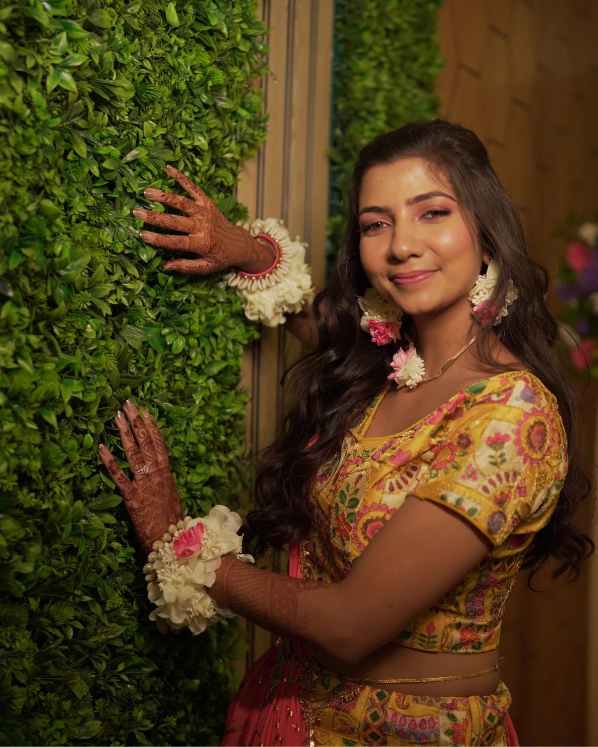 Woman in colourful traditional clothing beside foliage